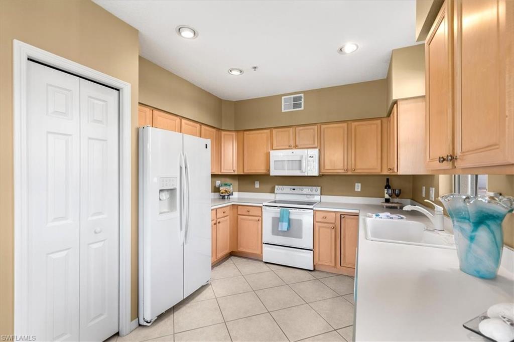2090 Aberdeen Lane, Unit 101 Naples, FL 34109 - Photo 16 of 42 a kitchen with a refrigerator and a sink