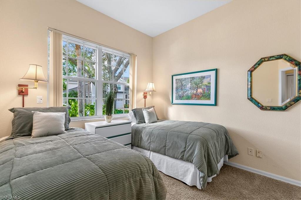 2090 Aberdeen Lane, Unit 101 Naples, FL 34109 - Photo 22 of 42 a bedroom with two beds and a large window