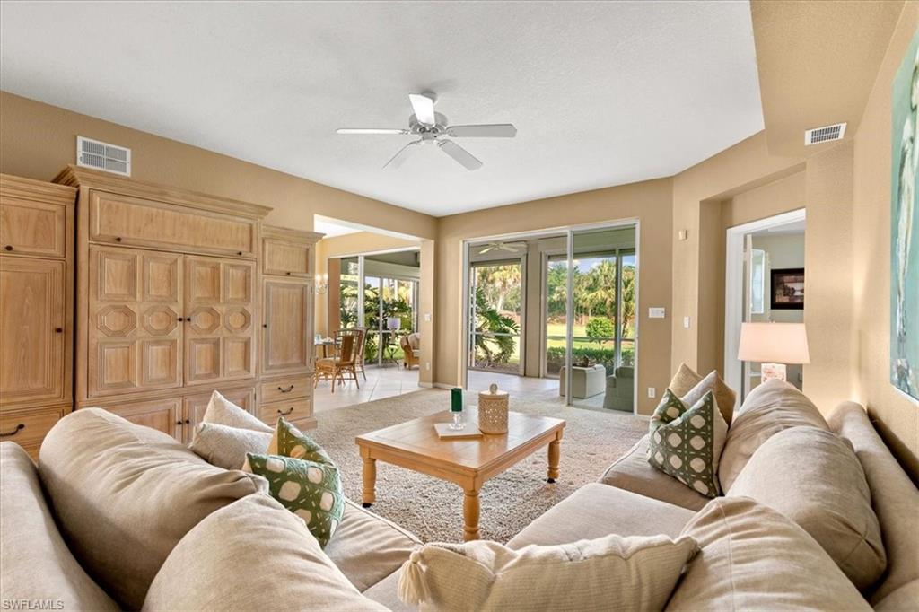 2090 Aberdeen Lane, Unit 101 Naples, FL 34109 - Photo 3 of 42 a living room with furniture and large windows
