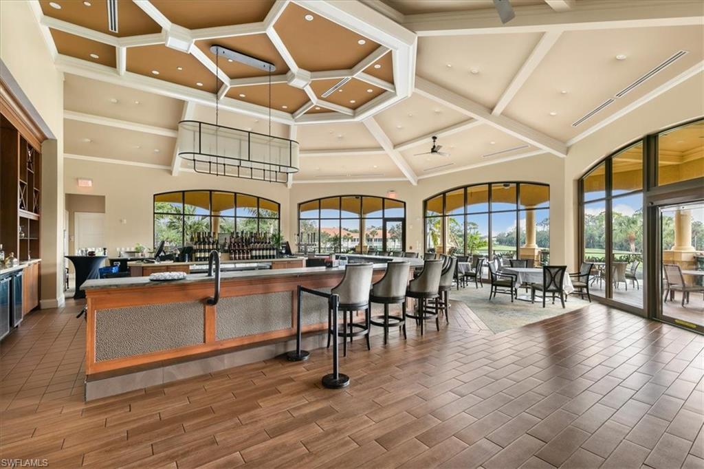 2090 Aberdeen Lane, Unit 101 Naples, FL 34109 - Photo 33 of 42 a dining hall with couches a dining table and chairs with wooden floor