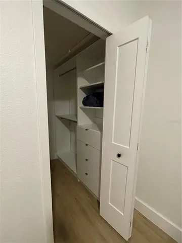 a view of walk in closet with wooden floor