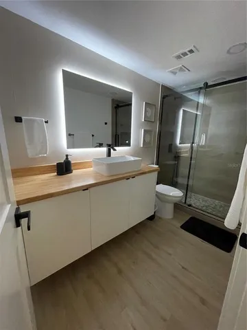 a bathroom with a double vanity sink a mirror and shower
