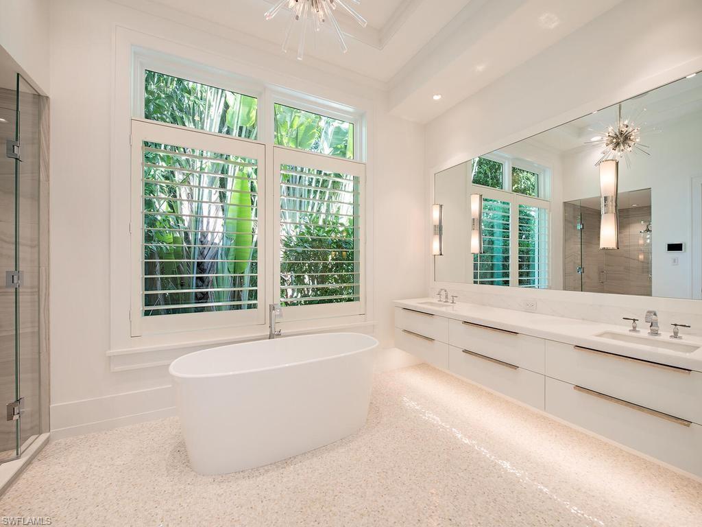 225 4th Avenue North Naples, FL 34102 - Photo 14 of 42 a bathroom with a large tub a sink and large window