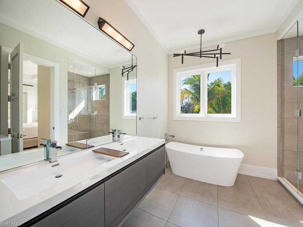 225 4th Avenue North Naples, FL 34102 - Photo 16 of 42 a bathroom with a tub sink and mirror