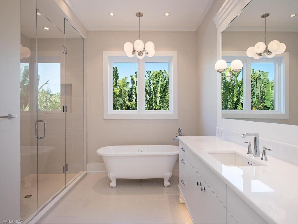 225 4th Avenue North Naples, FL 34102 - Photo 18 of 42 a bathroom with a sink tub and a mirror