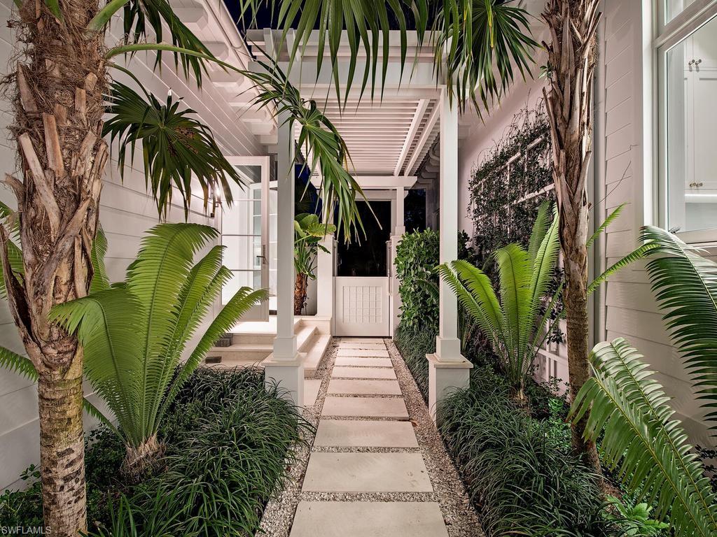 225 4th Avenue North Naples, FL 34102 - Photo 3 of 42 a view of a garden with palm trees