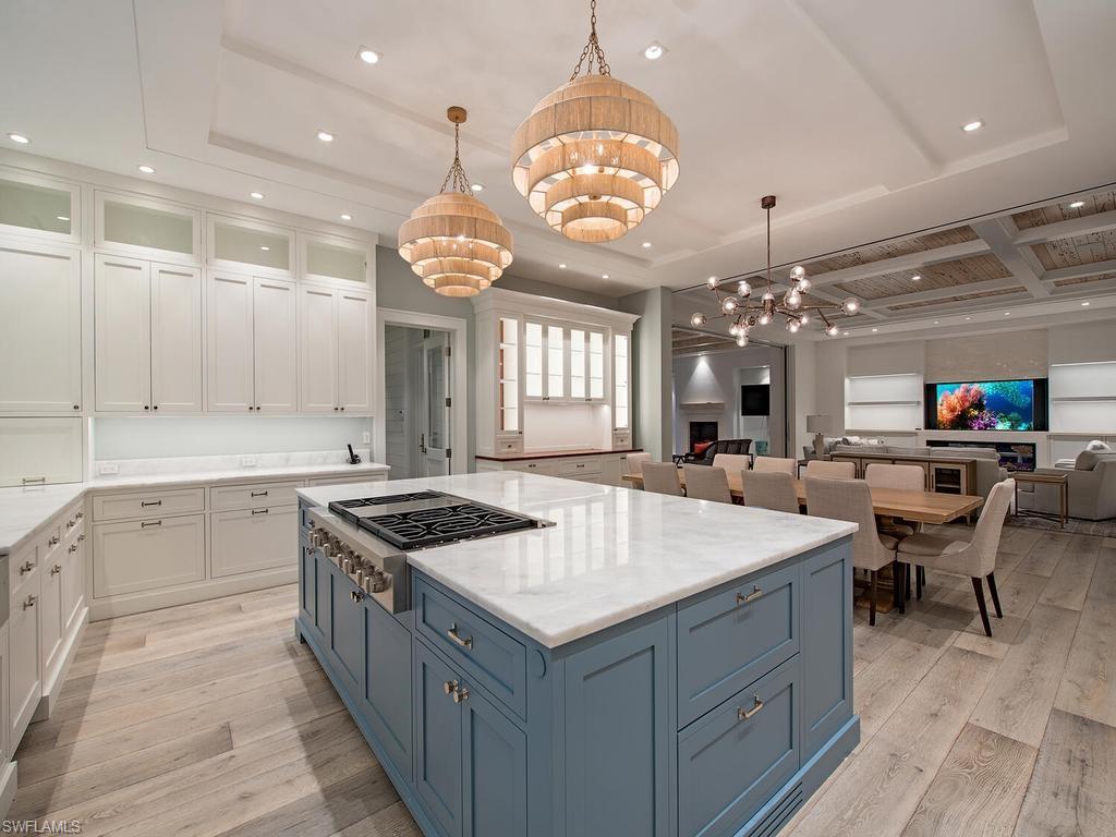 225 4th Avenue North Naples, FL 34102 - Photo 9 of 42 a kitchen with a stove a sink a dining table and chairs