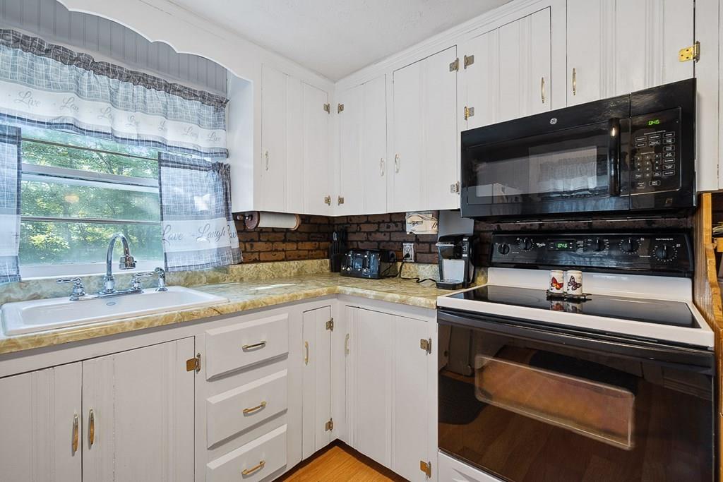 24 Springwell Road Billerica, MA 01821 - Photo 4 of 16 a kitchen with granite countertop white cabinets appliances and a window