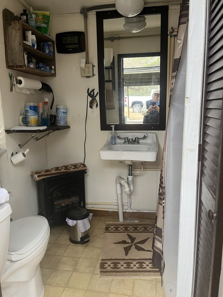 695 Big Shades Road Concan, TX 78838 - Photo 24 of 27 a bathroom with a sink toilet and a mirror