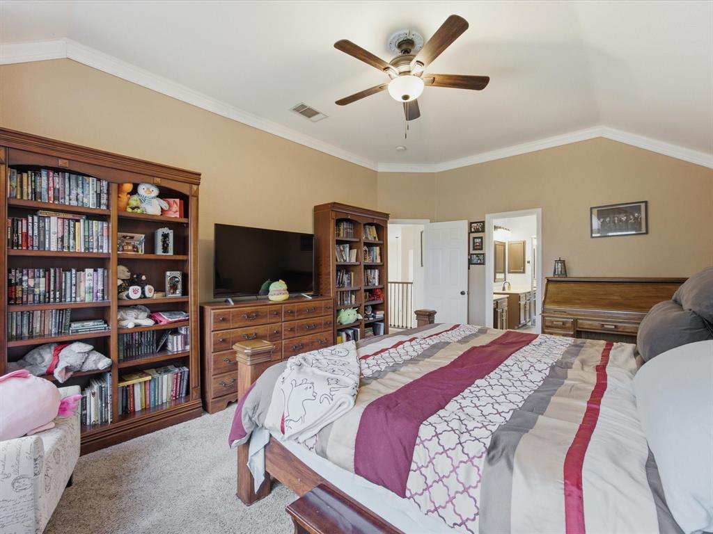 4008 Falcon Ridge Drive Haltom City, TX 76137 - Photo 23 of 40 Vaulted ceiling Primary bedroom with neutral wall tones and crown molding