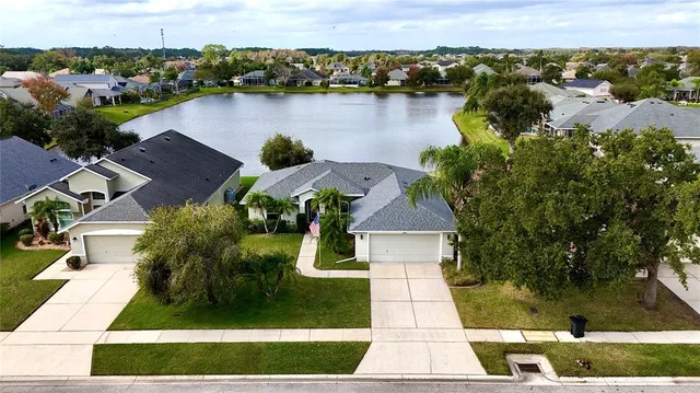 an aerial view of residential houses with outdoor space and lake view