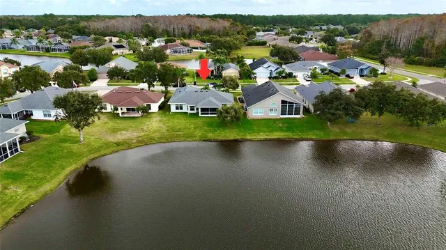 an aerial view of a house with yard and lake view