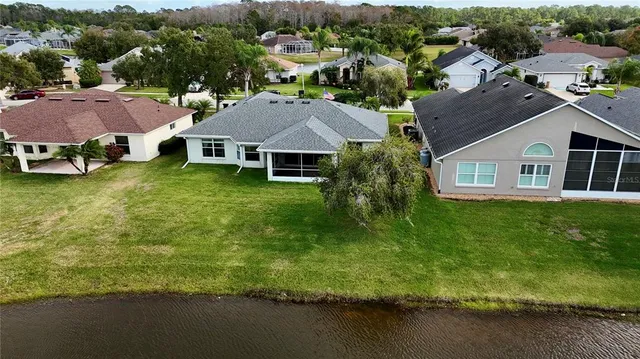 an aerial view of residential houses with outdoor space and trees