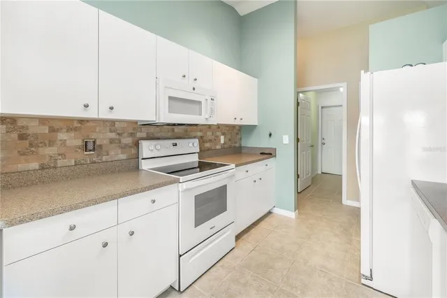 a kitchen with stainless steel appliances white cabinets and a refrigerator