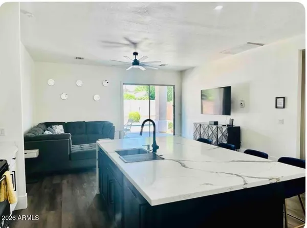 a kitchen with stainless steel appliances kitchen island granite countertop a sink and a refrigerator