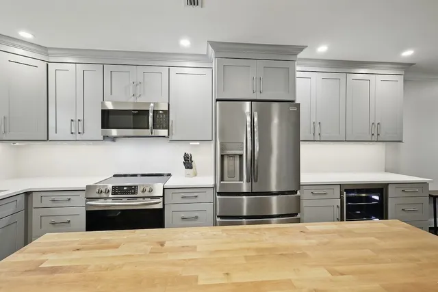 a kitchen with stainless steel appliances a refrigerator stove and microwave