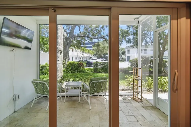a dining room with furniture and a floor to ceiling window