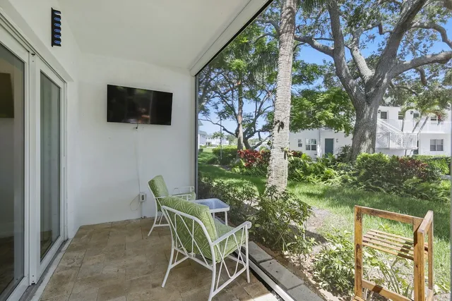 a patio with table and chairs and potted plants