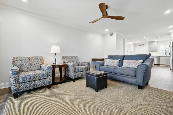 a living room with furniture and a ceiling fan