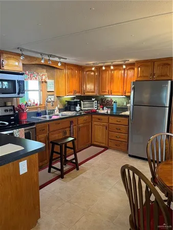 a kitchen with stainless steel appliances granite countertop a sink a stove and a refrigerator