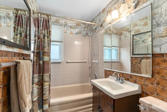 a bathroom with a sink mirror toilet and bathtub