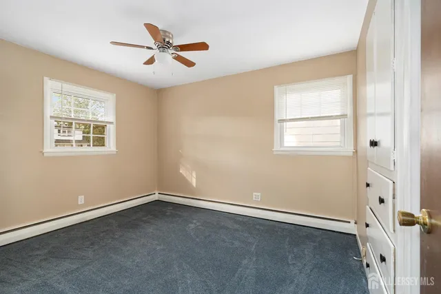an empty room with a window and a ceiling fan