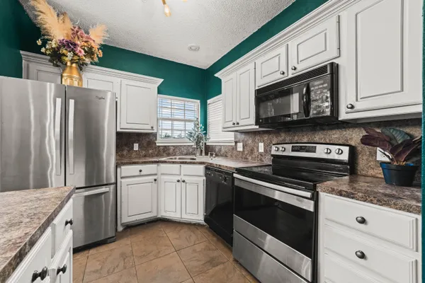 a kitchen with granite countertop cabinets stainless steel appliances and a counter space
