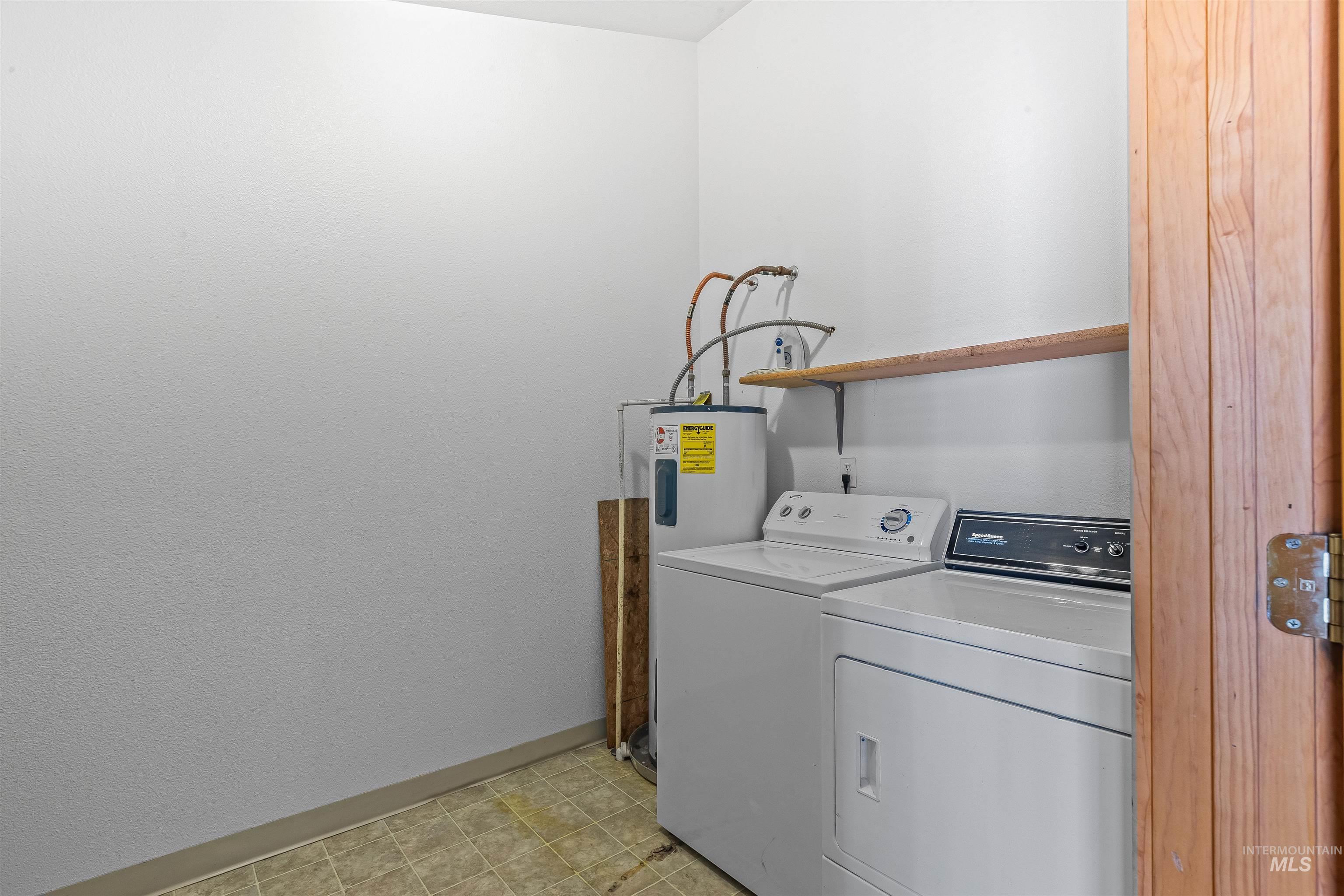 302 Berger Street Riggins, ID 83549 - Photo 30 of 47 Laundry room featuring electric water heater and washer and clothes dryer