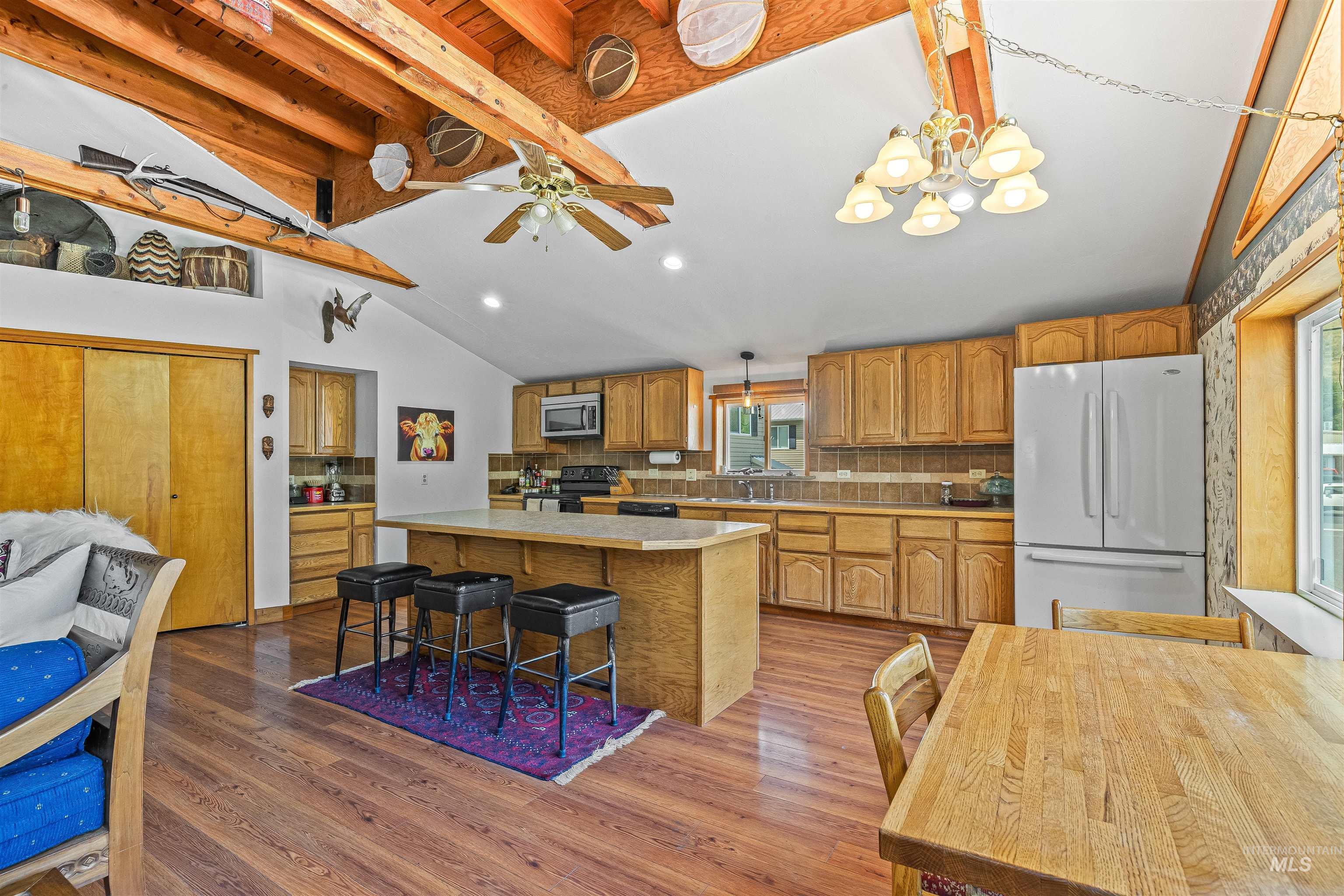 302 Berger Street Riggins, ID 83549 - Photo 5 of 47 Kitchen with freestanding refrigerator, stainless steel microwave, electric range, backsplash, and wood finished floors