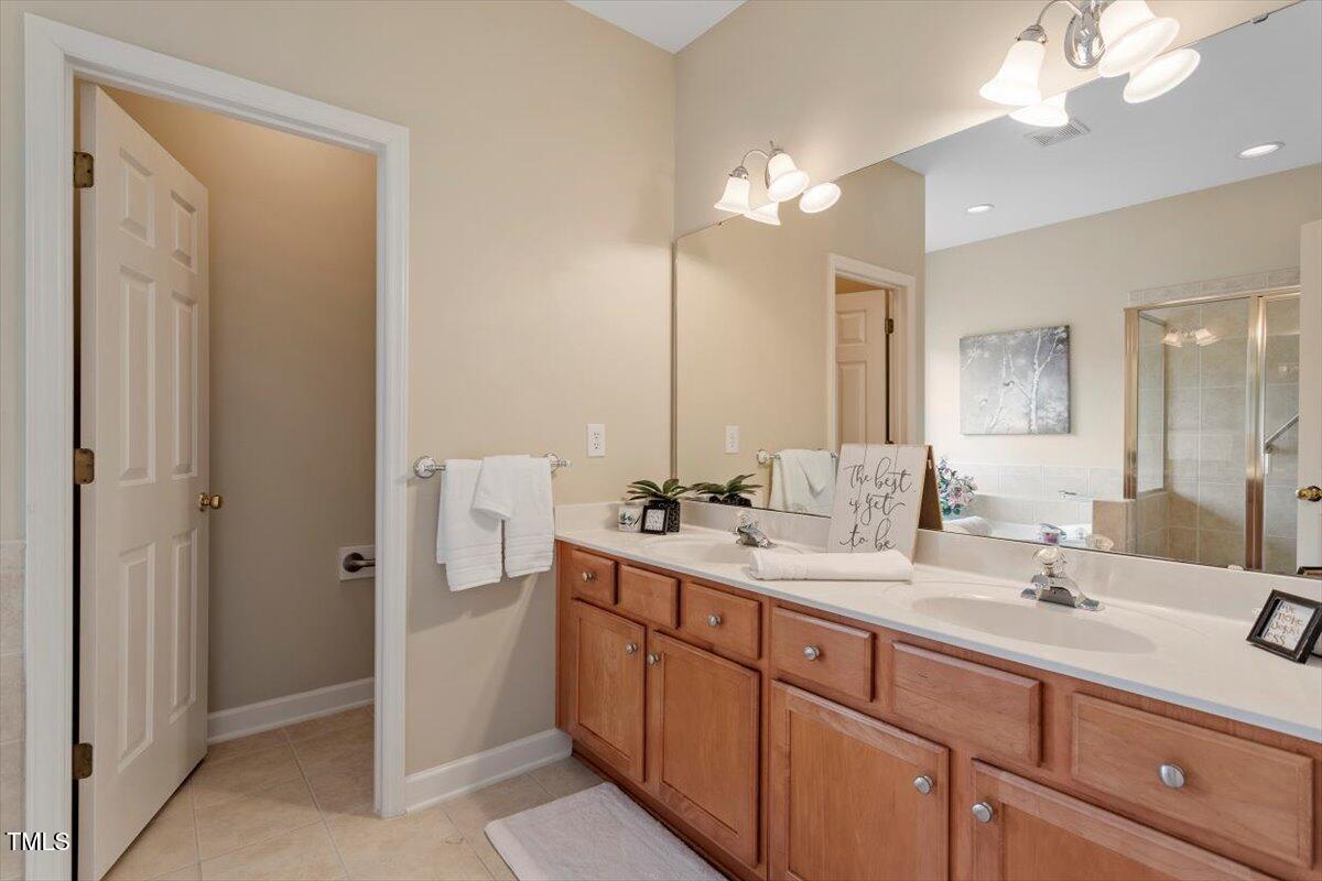 2524 Forest Shadows Lane Raleigh, NC 27614 - Photo 30 of 48 a bathroom with a double vanity sink and a mirror