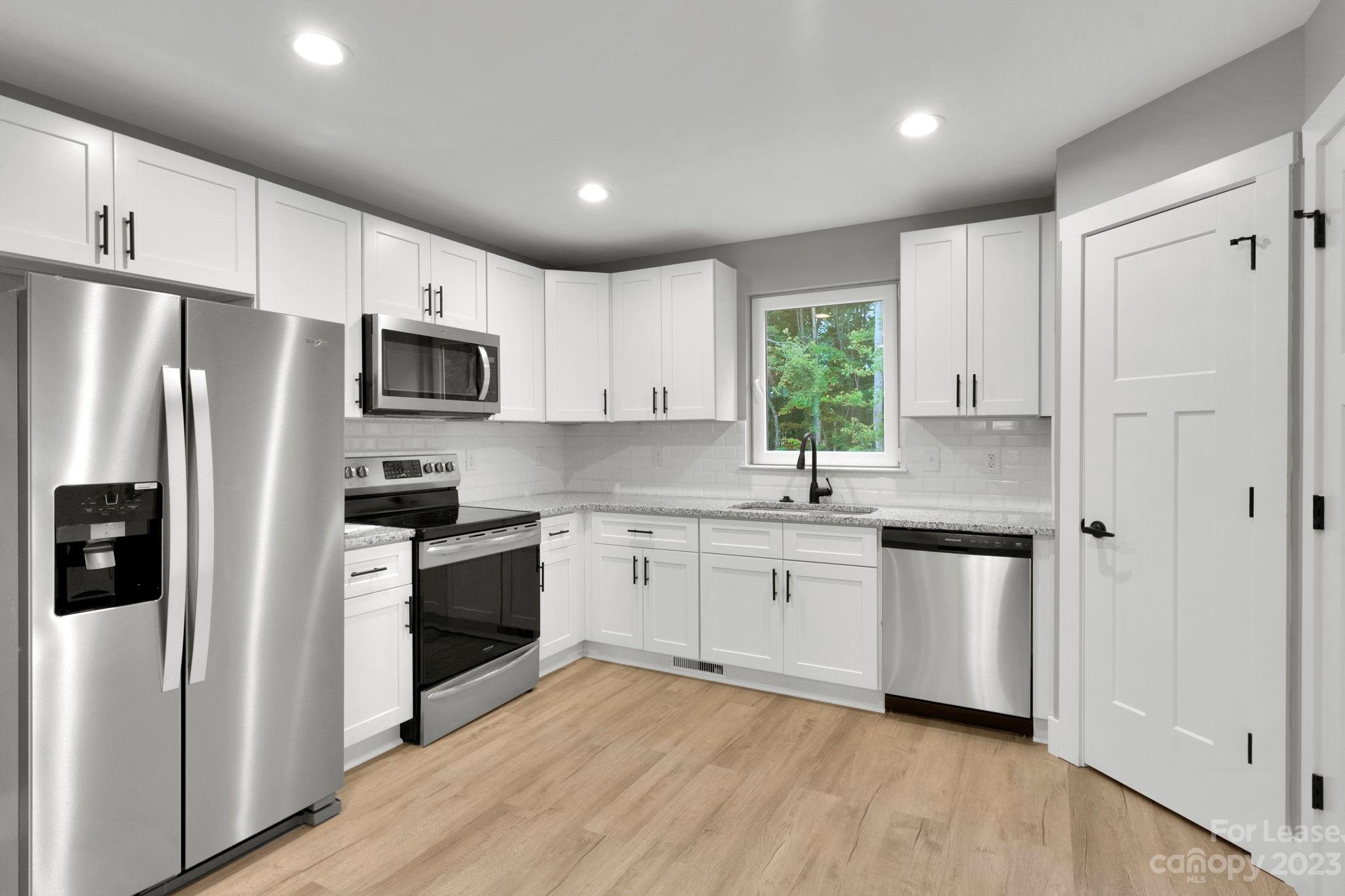385 Roper Drive Lincolnton, NC 28092 - Photo 2 of 13 a kitchen with granite countertop white cabinets and stainless steel appliances