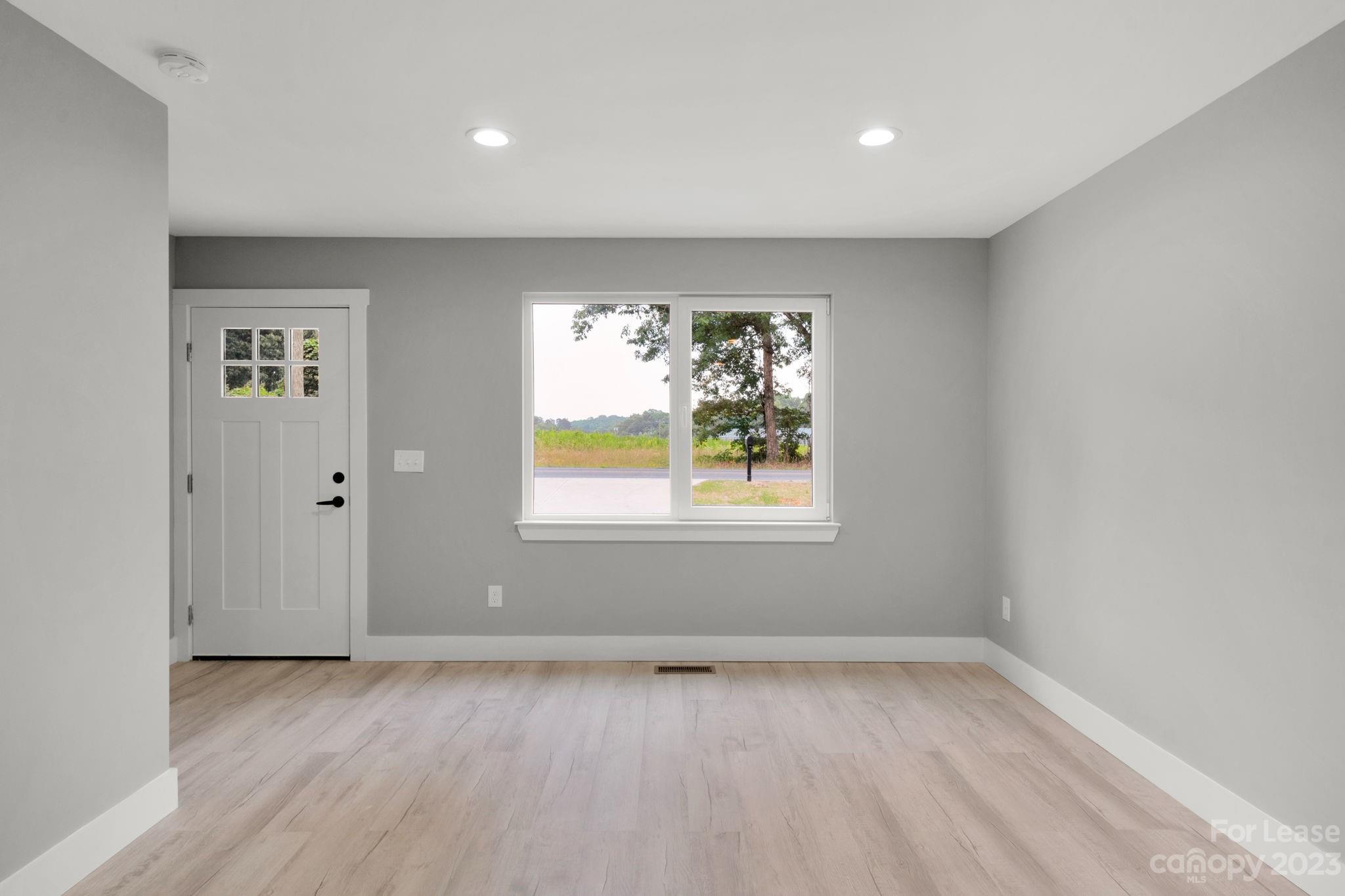 385 Roper Drive Lincolnton, NC 28092 - Photo 5 of 13 wooden floor in an empty room with a window