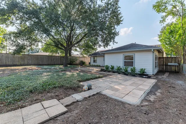 a view of a yard in front of a house with large tree