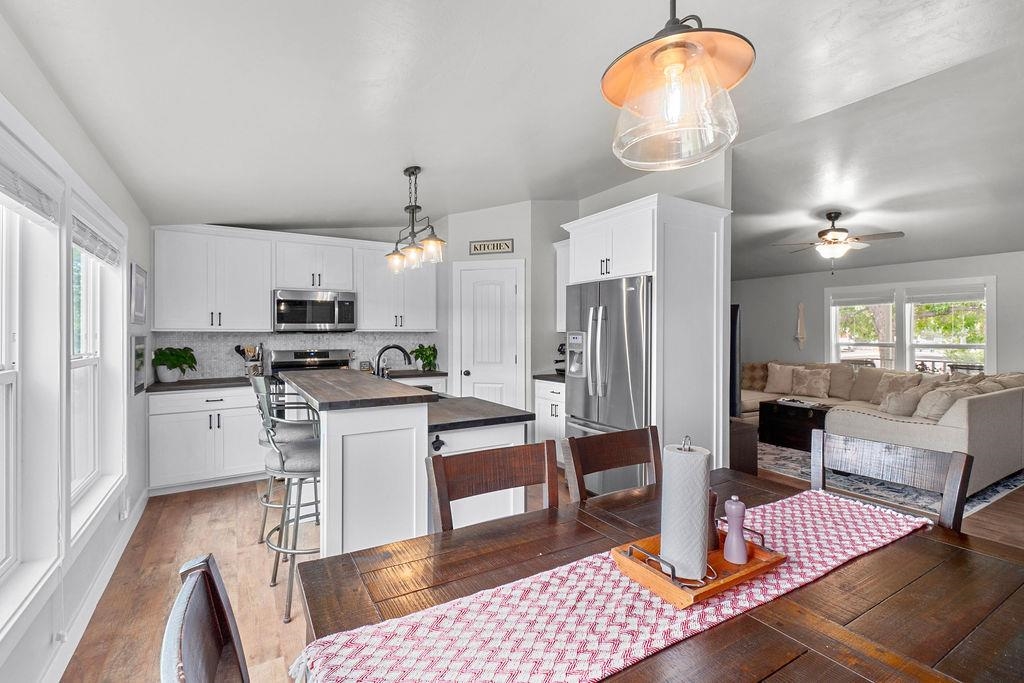 435 32 Road, Unit 601 Clifton, CO 81520 - Photo 7 of 26 a kitchen with stainless steel appliances kitchen island granite countertop a refrigerator a stove a microwave and a dining table with wooden floor
