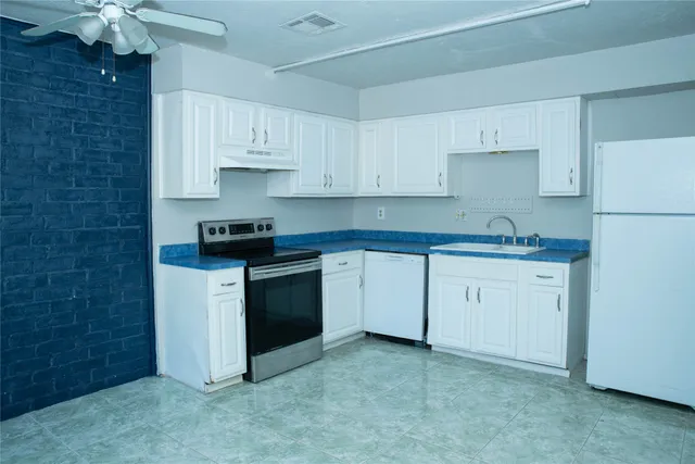 a kitchen with white cabinets stainless steel appliances and sink