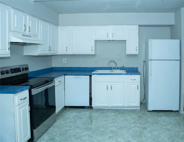 a kitchen with stainless steel appliances a stove a refrigerator and cabinets