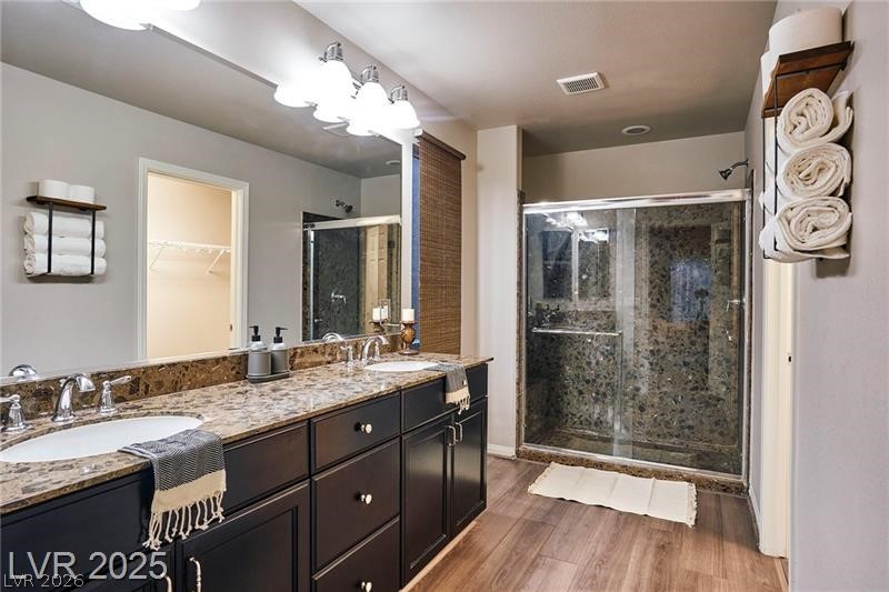 6302 Jackson Spring Road Las Vegas, NV 89118 - Photo 11 of 23 Dual vanities with granite counters complement the spacious walk-in shower in this refined bathroom.