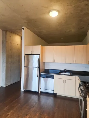 a kitchen with stainless steel appliances a refrigerator a sink and white cabinets