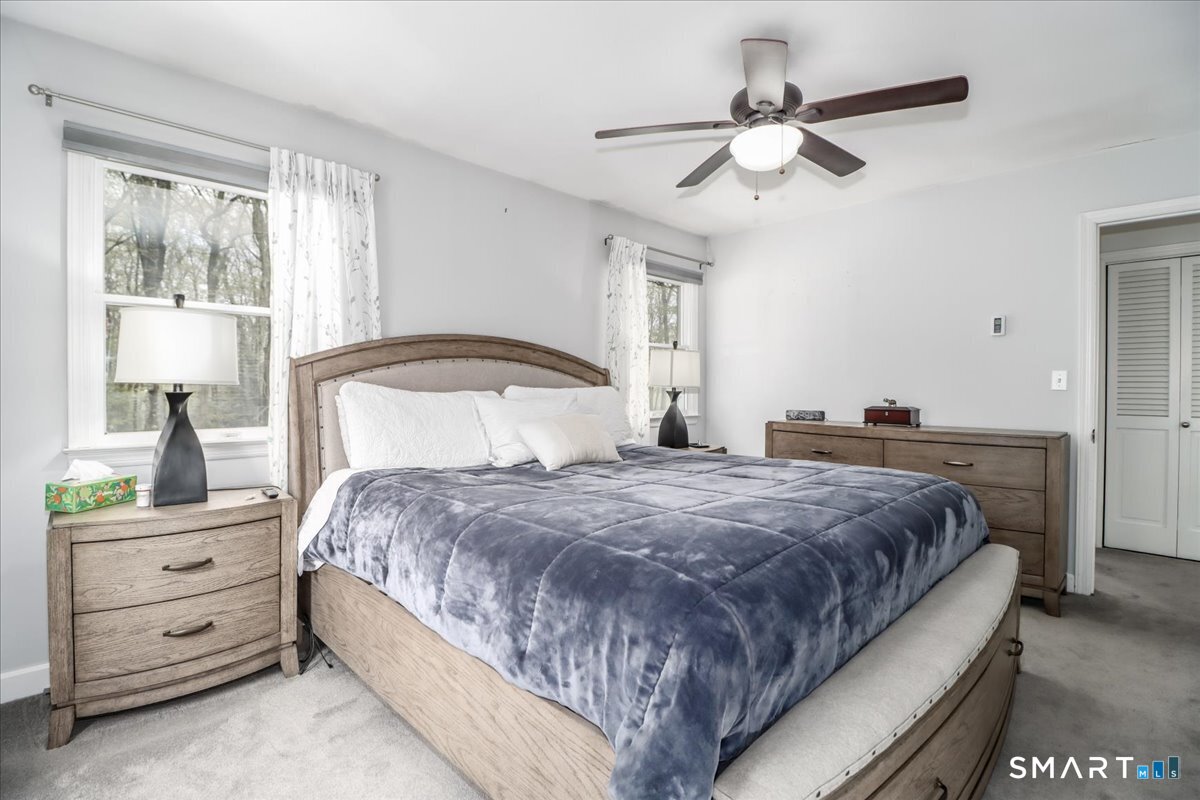 4 Farrell Road Newtown, CT 06470 - Photo 19 of 36 a bedroom with a bed and a chandelier