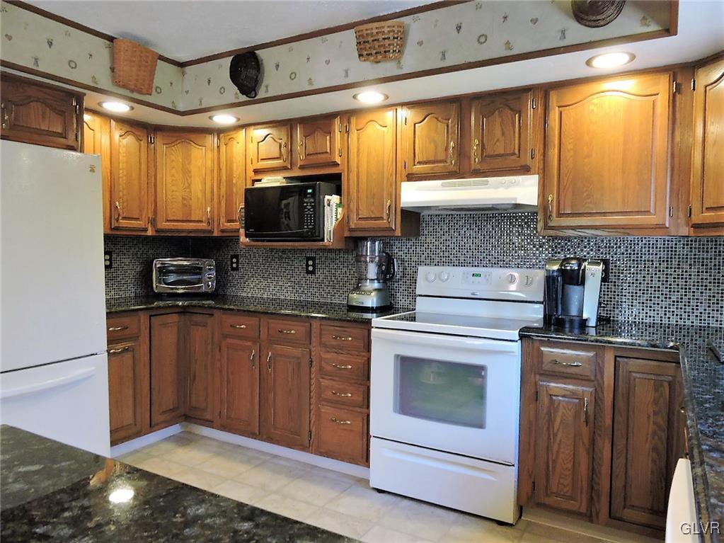 621 Long Mountain Road Effort, PA 18330 - Photo 8 of 22 a kitchen with stainless steel appliances granite countertop a stove a sink and a microwave