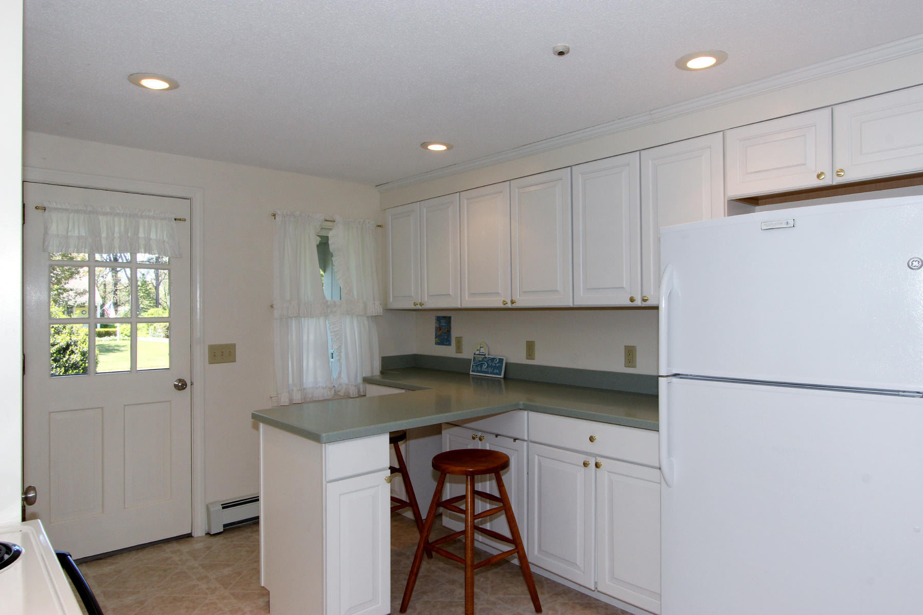 167 Ambergris Circle Brewster, MA 02631 - Photo 9 of 28 a kitchen with a refrigerator and white cabinets