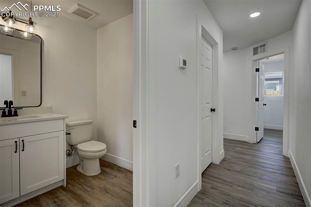 1436 Brewery Road Pueblo, CO 81001 - Photo 15 of 40 Half bath with visible vents, toilet, and wood finished floors