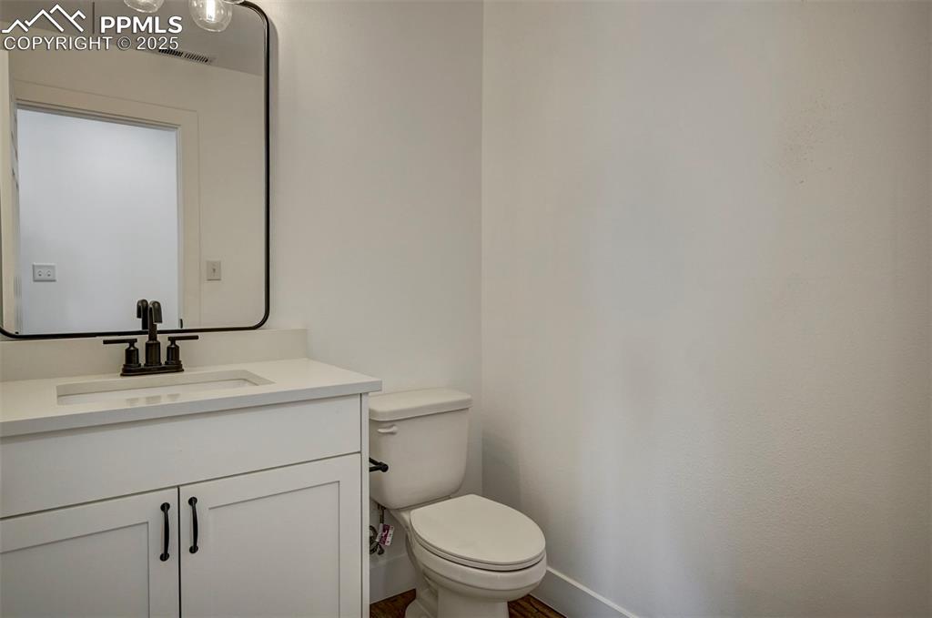 1436 Brewery Road Pueblo, CO 81001 - Photo 16 of 40 Half bathroom featuring baseboards, visible vents, toilet, and vanity