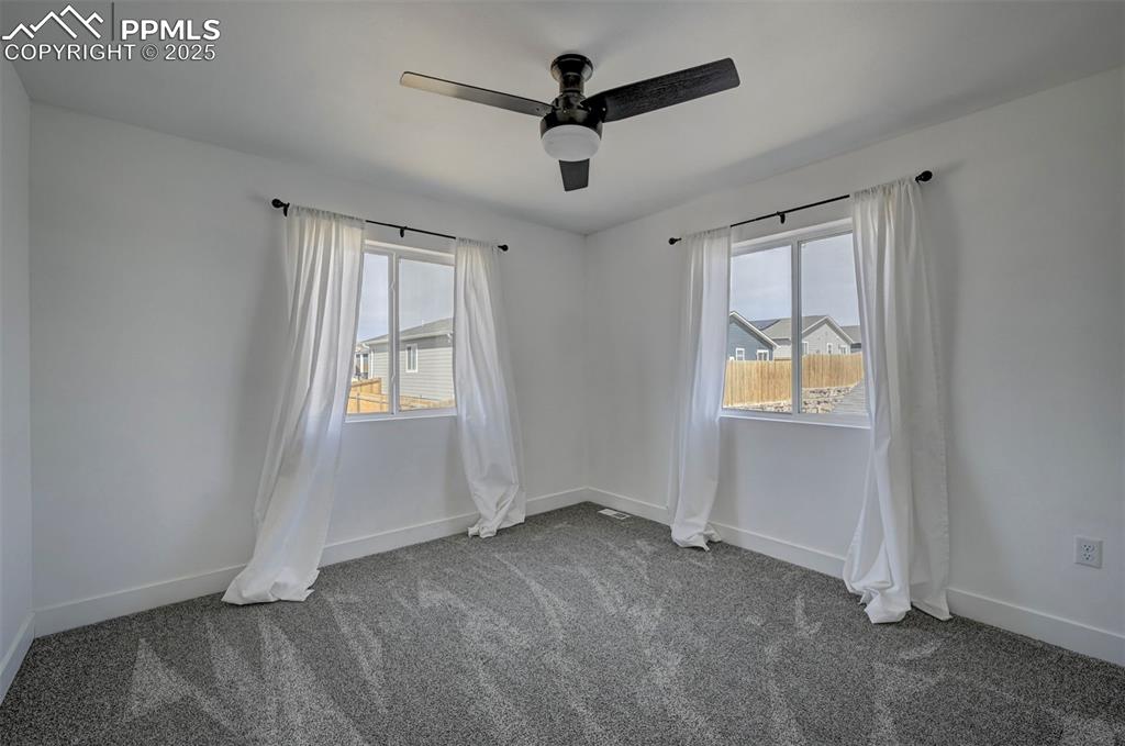 1436 Brewery Road Pueblo, CO 81001 - Photo 27 of 40 Carpeted spare room featuring baseboards, ceiling fan, and a wealth of natural light