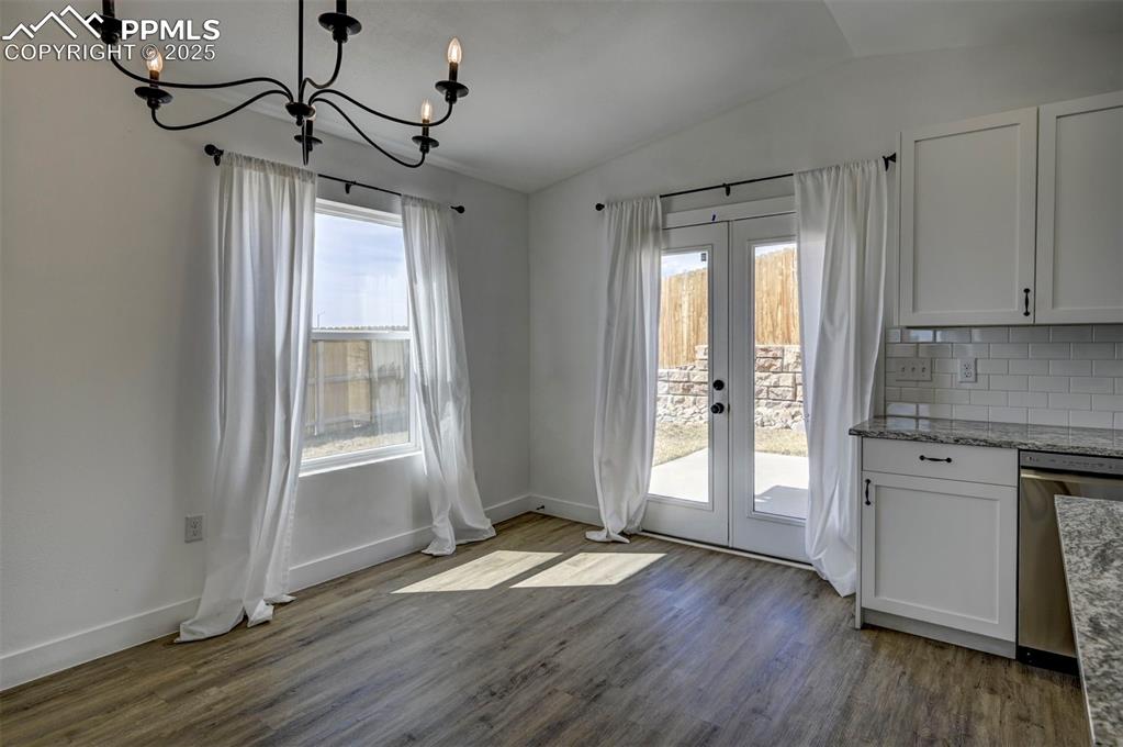 1436 Brewery Road Pueblo, CO 81001 - Photo 6 of 40 Unfurnished dining area with vaulted ceiling, a notable chandelier, french doors, and a healthy amount of sunlight