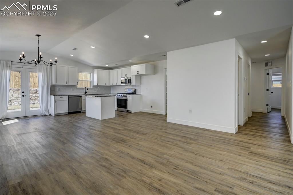 1436 Brewery Road Pueblo, CO 81001 - Photo 9 of 40 Kitchen with open floor plan, an inviting chandelier, white cabinetry, and stainless steel appliances