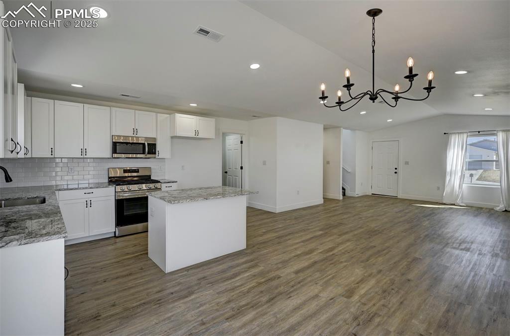 1436 Brewery Road Pueblo, CO 81001 - Photo 10 of 40 Kitchen featuring a sink, appliances with stainless steel finishes, open floor plan, lofted ceiling, and visible vents