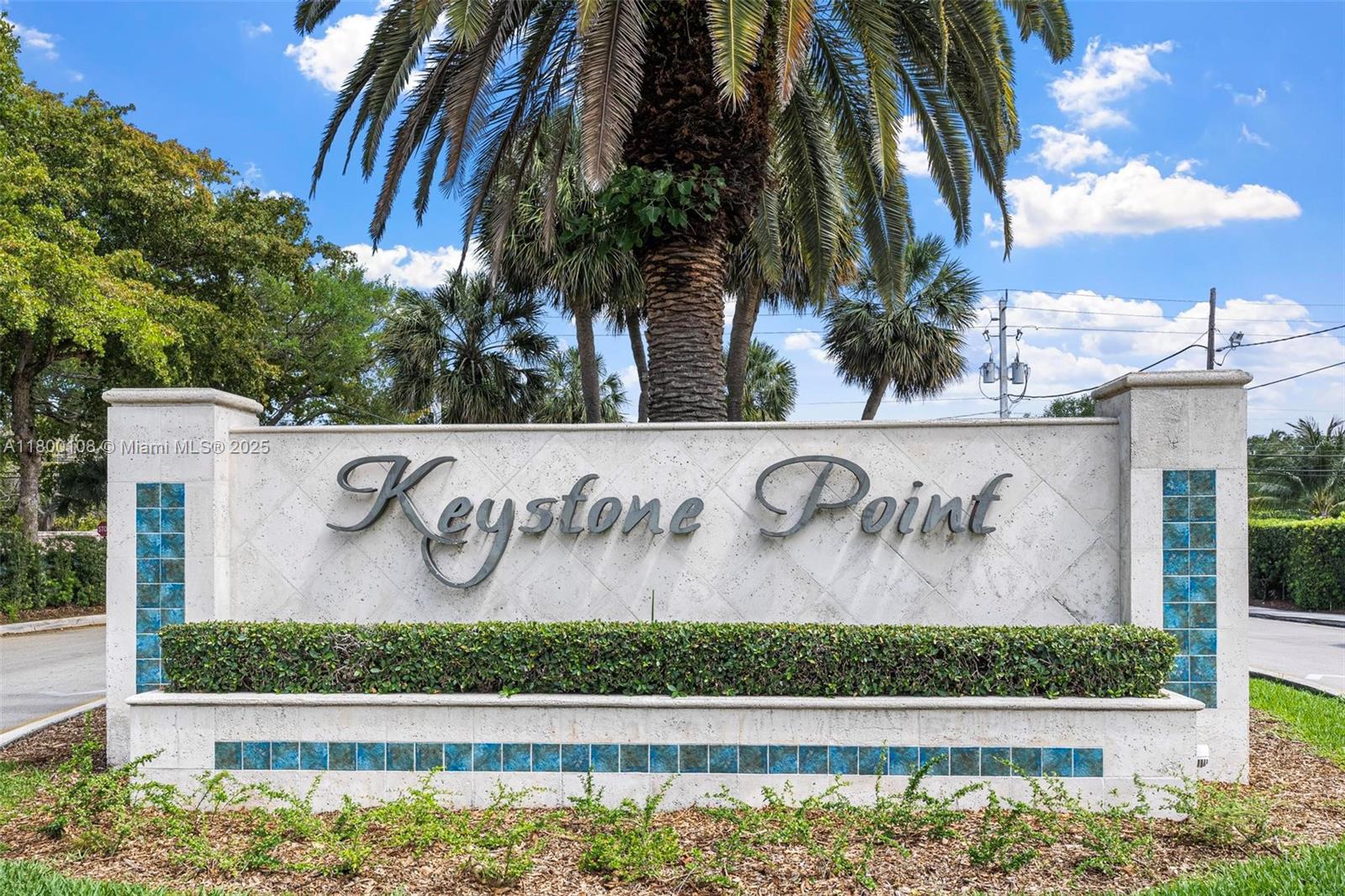 12605 Cyprus Road North Miami, FL 33181 - Photo 2 of 60 a street sign on a wall with potted plants