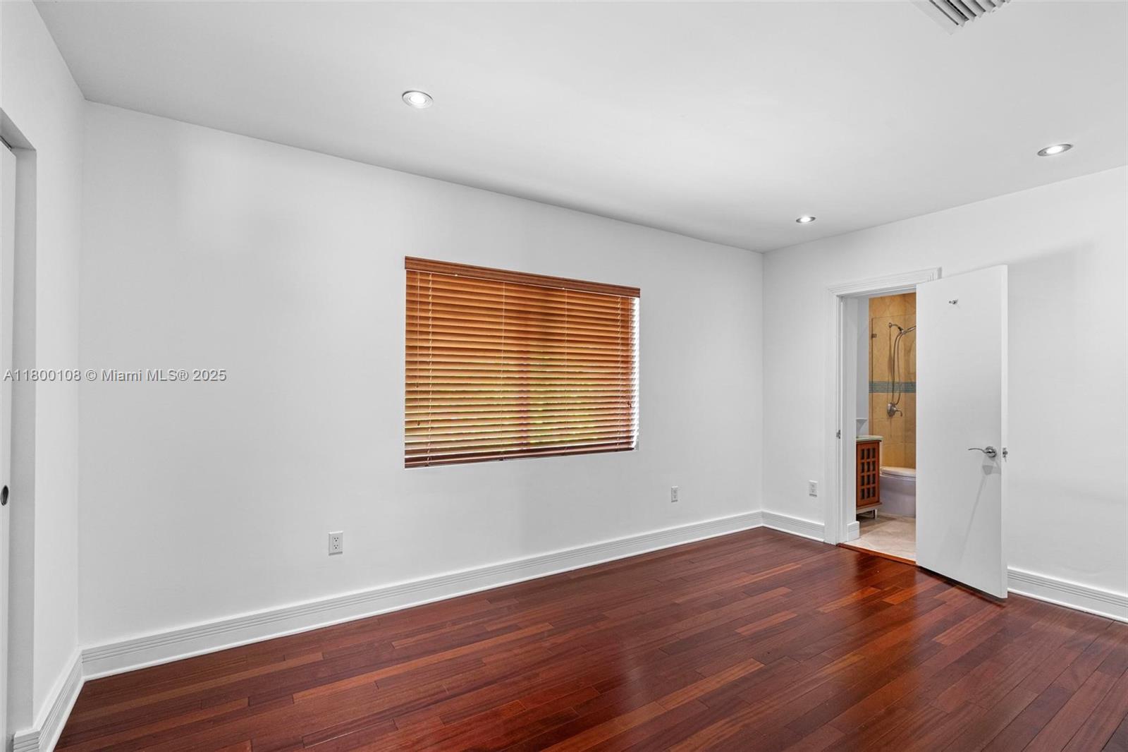 12605 Cyprus Road North Miami, FL 33181 - Photo 23 of 60 a view of an empty room with wooden floor and a window