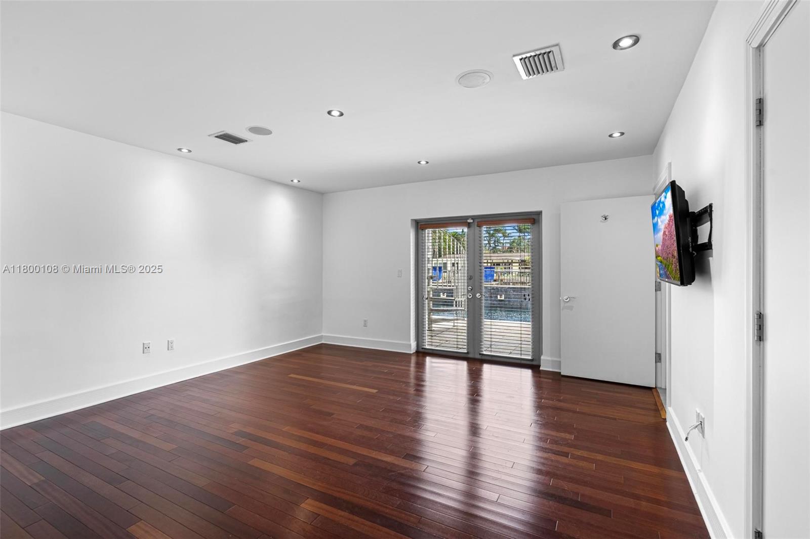 12605 Cyprus Road North Miami, FL 33181 - Photo 25 of 60 a view of an empty room with wooden floor and a window